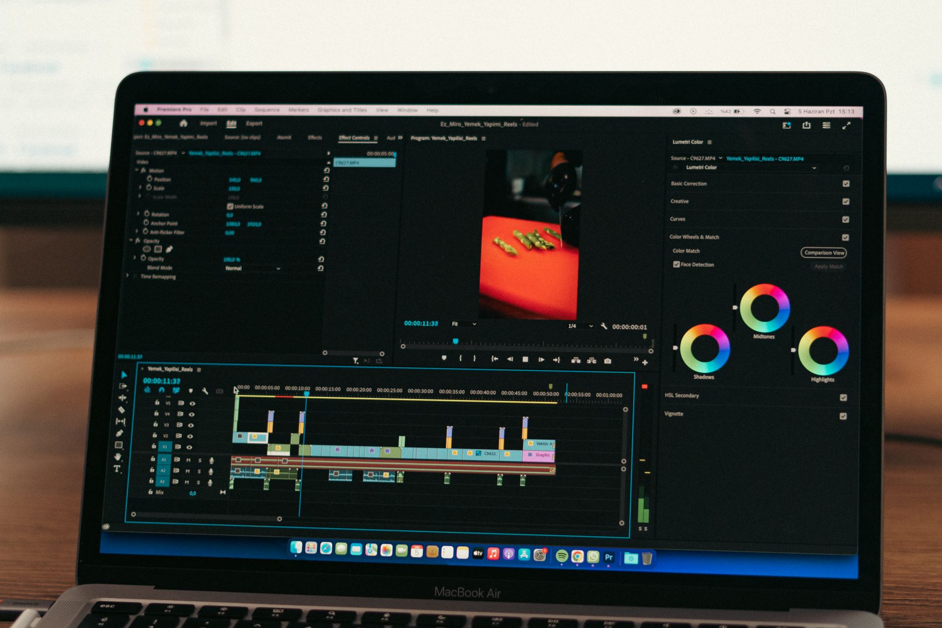 Gros plan sur un ordinateur portable affichant un logiciel de montage vidéo, avec la timeline et les réglages de couleur.